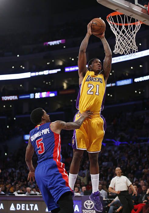 Ed Davis, de los Lakers de Los Angeles, hace un mate frente a su rival de los Pistons de Detroit Kentavious Caldwell-Pope durante la segunda mitad de su partido de la NBA, el 10 de marzo de 2015 en Los Angeles. (Foto AP/Danny Moloshok)