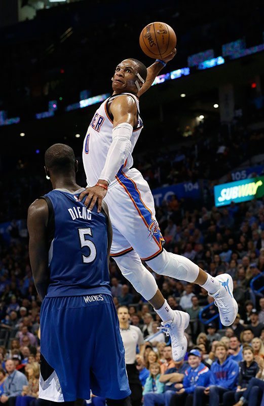 Russell Westbrook (0) se eleva para clavar el balón sobre Gorgui Dieng (5) durante el tercer cuarto del partido de NBA en Oklahoma City frente a los Timberwolves. (Foto AP/Sue Ogrocki)